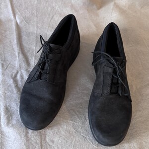 Op de afbeelding: Een paar zwarte veterschoenen. De schoenen hebben een ronde neus en een lage hak. De bovenkant lijkt van su&egrave;de of een vergelijkbaar materiaal te zijn. De veters zijn zwart en vastgeknoopt.