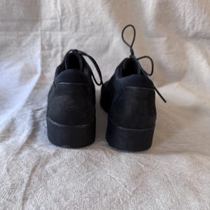 Op de afbeelding: Een paar zwarte veterschoenen met een bovenwerk met textuur en een dikke zool. De schoenen zijn gemaakt van een mat materiaal en worden gepresenteerd tegen een neutrale achtergrond.