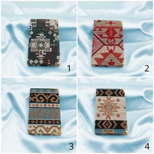 May include: Four different patterned fabric covered notebooks with gold trim. The notebooks are arranged in a grid pattern on a light blue background.