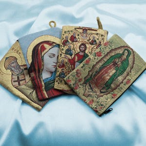 May include: Four small pouches with zipper closures, each featuring a different religious icon. The icons are embroidered in gold thread on a colorful fabric background. The pouches are ideal for holding small items like jewelry or cash.