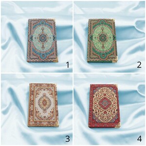 May include: Four small notebooks with different patterned covers. Each cover features a colourful design inspired by traditional rugs. The covers are blue, green, beige, and red.