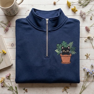 May include: A white ceramic mug with a black handle and the text "But First, Coffee" in a black, handwritten-style font. The mug is on a white surface.