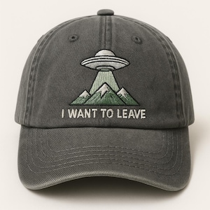 May include: Gray baseball cap with an embroidered design of a UFO above green mountains. The text "I WANT TO LEAVE" is embroidered below the design. The cap has a curved brim and an adjustable strap.
