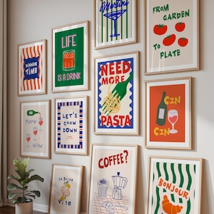 May include: A selection of framed art prints with food and drink themes. Prints feature phrases such as "Dinner Time," "Life is a Drink," "Need More Pasta," and "Coffee?" The color scheme includes red, green, blue, and orange.