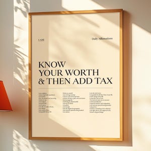 May include: A framed print with the text "KNOW YOUR WORTH & THEN ADD TAX". The print also includes a list of affirmations. The frame is a light brown colour, and the background is a cream colour.