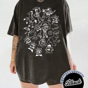 Camiseta unisex de Disney Pixar Toy Story Doodles Comfort Colors, camiseta de dibujos animados de Woody y Buzz Lightyear, camiseta a juego para regalar en un viaje familiar a Disneyland. Black