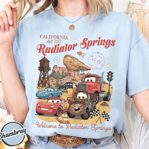 Pode incluir: Uma caneca de cer&acirc;mica branca com uma al&ccedil;a preta e o texto "But First, Coffee" em negrito preto. A caneca est&aacute; sobre um fundo neutro, destacando seu design simples.