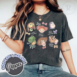 K&ouml;nnte beinhalten: Eine wei&szlig;e Keramik-Tasse mit schwarzem Henkel und dem Text "But First, Coffee" in fetter, schwarzer Schrift. Die Tasse steht vor einem neutralen Hintergrund, der ihr schlichtes Design hervorhebt.