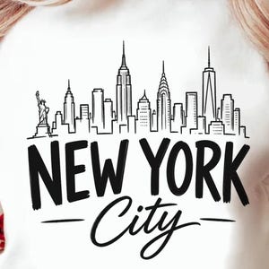 May include: A white long-sleeve sweatshirt featuring a black line art illustration of the New York City skyline, including the Statue of Liberty. Below the skyline, the text NEW YORK City is printed in a bold, black, sans-serif and script font.