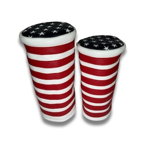 May include: Two golf club headcovers with a red and white striped design and a blue and white star pattern on the top.