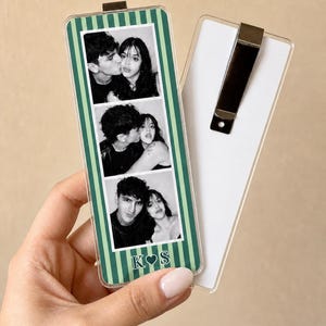 May include: A rectangular acrylic bookmark featuring a green and light green vertical striped border. The center displays three black and white photo booth strips of a couple, with the letters K and S separated by a heart at the bottom.