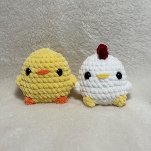 May include: Two handmade crochet chicks. One is yellow with an orange beak and feet, the other is white with a red comb and yellow feet. Both have black eyes and are made of soft yarn.