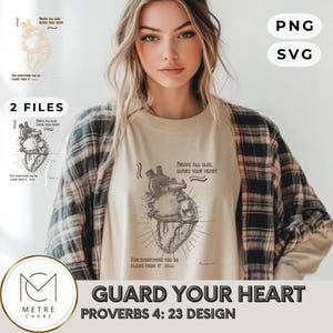 May include: A beige t-shirt with a detailed anatomical heart graphic and the text "ABOVE ALL ELSE, GUARD YOUR HEART" and "FOR EVERYTHING YOU DO FLOWS FROM IT". The design also includes the text "PROVERBS 4: 23 DESIGN".