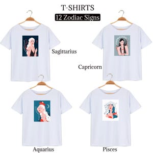 Peut inclure: Quatre t-shirts blancs avec diff&eacute;rents signes du zodiaque imprim&eacute;s dessus. Les signes sont Sagittaire, Capricorne, Verseau et Poissons. Chaque t-shirt a un cintre attach&eacute; en haut.