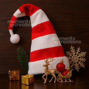 May include: A festive Christmas scene featuring a red and white striped Santa hat with a white pom-pom. Gold reindeer pulling a sleigh with a red ornament, gold snowflake, and wrapped gifts. The hat has the text "moments creations".