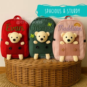 Può includere: Tre zaini per bambini colorati. Lo zaino rosso ha il nome "Evan" ricamato in verde. Lo zaino verde ha il nome "Maeice" ricamato in verde. Lo zaino rosa ha il nome "Maddison" ricamato in viola. Ogni zaino presenta un orsacchiotto.