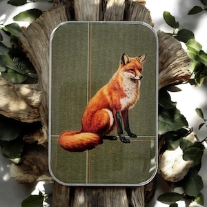 May include: A rectangular decorative tray with a detailed illustration of a red fox with black legs and a fluffy tail, set against a textured green background. The tray has a clear, rounded edge and is surrounded by natural wood and greenery.