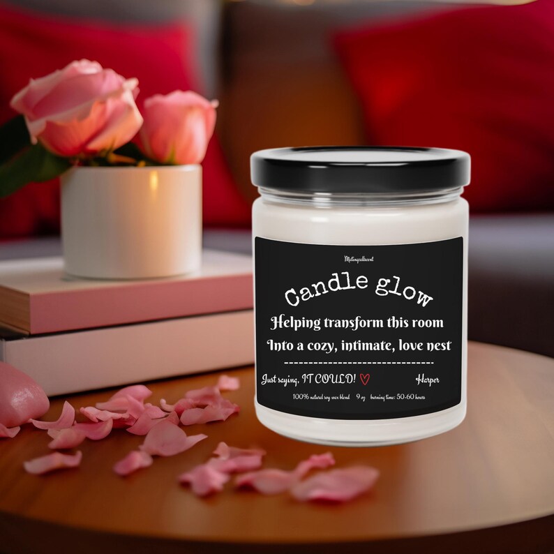 May include: A white candle jar with a black lid and label. The label reads "Candle glow" and "Helping transform this room into a cozy, intimate, love nest. Just saying, IT COULD!" with a heart symbol. The label also includes "Harper" and "100% soy wax blend 9 oz burning time 50-60 hours."