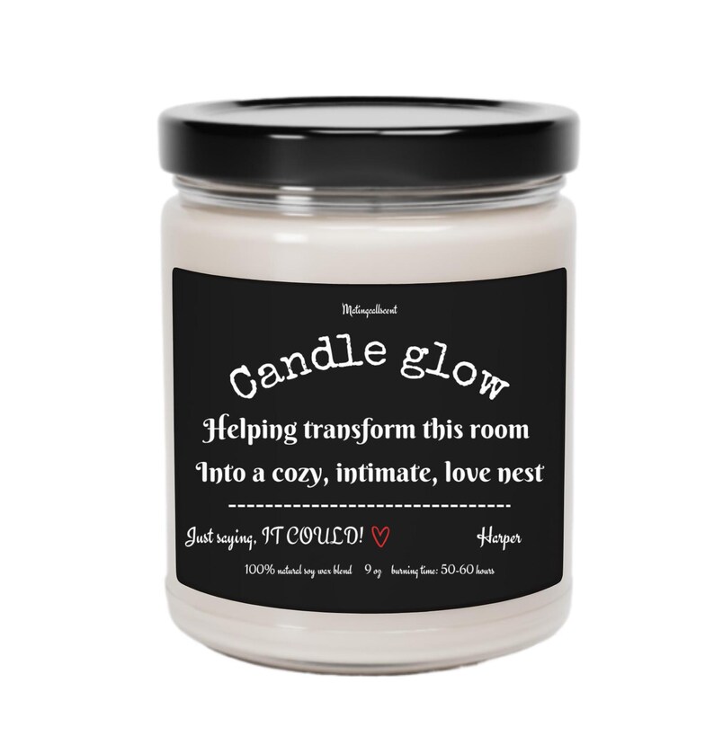 May include: A black and white candle jar with the text "Candle glow" and "Helping transform this room into a cozy, intimate, love nest. Just saying, IT COULD!" with a red heart. The candle is 9 oz and has a burn time of 50-60 hours.