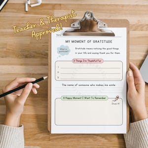 May include: A white paper worksheet titled My Moment of Gratitude on a brown clipboard. The form includes sections for three things to be thankful for, the name of someone who makes me smile, and a space to draw a happy moment to remember.