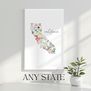 May include: A white printable art print featuring a floral outline of the state of California with the word "california" written in cursive. The print is ready to be framed and displayed in a home or office.