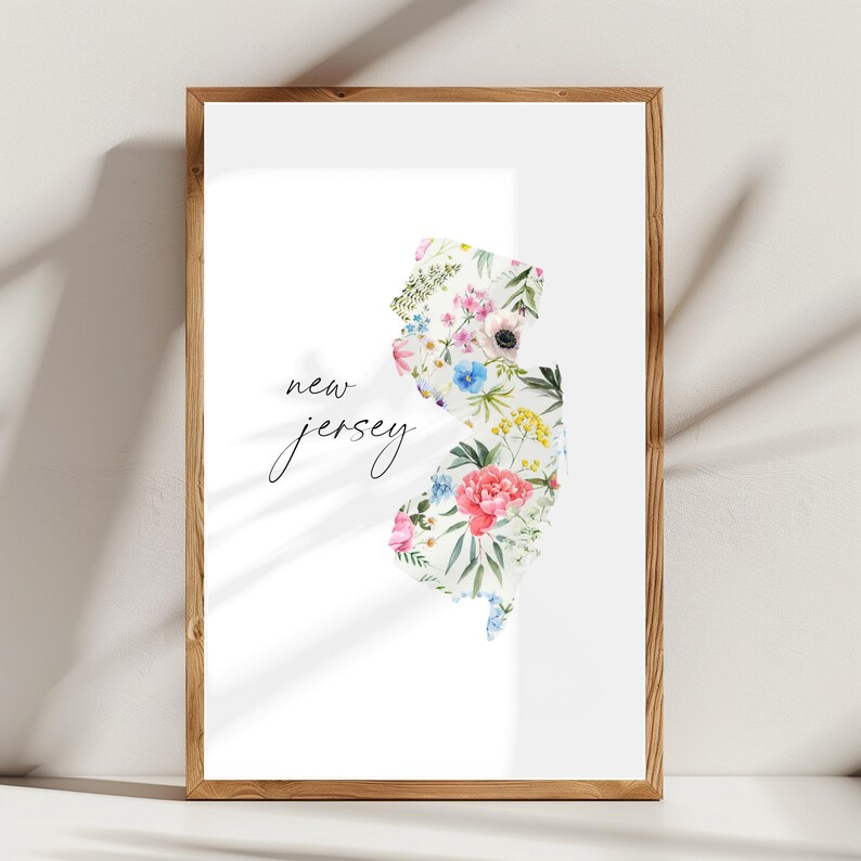 May include: A white print with the text "new jersey" in black script. The state of New Jersey is outlined in white and filled with a watercolor floral design in shades of pink, blue, yellow, and green.
