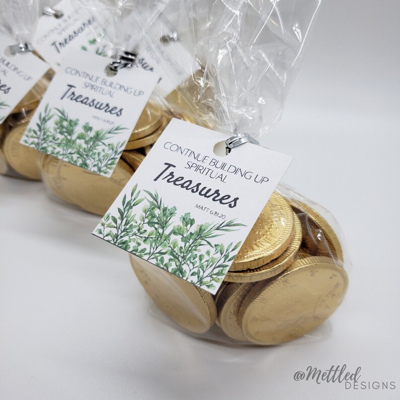 May include: A clear plastic bag filled with gold chocolate coins. A white tag with green foliage is attached to the bag. The tag reads "Continue Building Up Spiritual Treasures Matt 6:20".