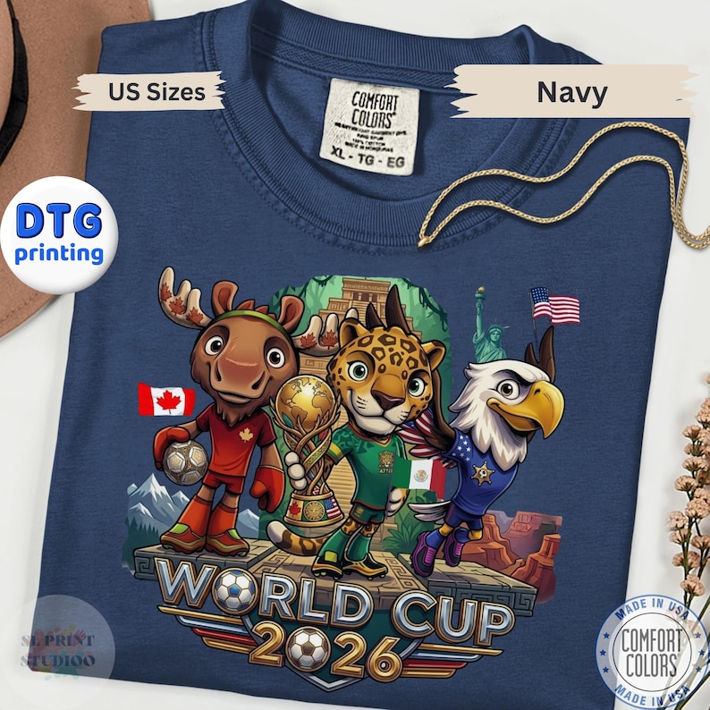 Navy blue World Cup 2026 graphic t-shirt featuring cartoon animal mascots representing USA Canada and Mexico soccer tournament fans.