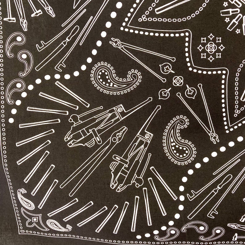 Puede incluir: Bandana de color negro y blanco con estampado paisley y un dise&ntilde;o de varias herramientas, incluyendo alicates, destornilladores y llaves.