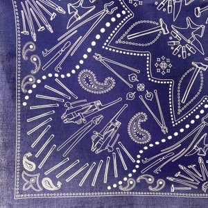 Puede incluir: Un pa&ntilde;uelo azul con un patr&oacute;n paisley blanco y un dise&ntilde;o repetido de varias herramientas, incluyendo martillos, alicates y llaves.