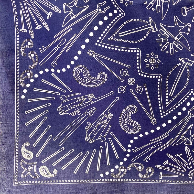 Puede incluir: Un pa&ntilde;uelo azul con un patr&oacute;n paisley blanco y un dise&ntilde;o repetido de varias herramientas, incluyendo martillos, alicates y llaves.