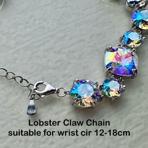 May include: A silver bracelet with a lobster claw clasp and iridescent crystal stones. The bracelet is suitable for a wrist circumference of 12-18 cm.