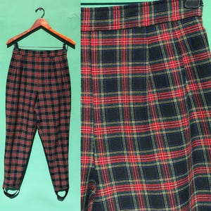 May include: Black, red, and green plaid pants with stirrups. The pants have a high waist and a slim fit.
