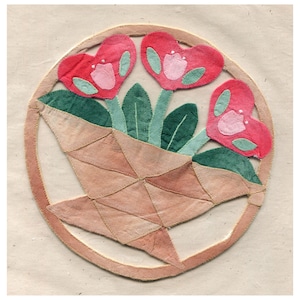 May include: A circular applique featuring a basket of flowers. The basket is a light brown colour, and the flowers are heart-shaped and pink with green leaves. The applique is set against a neutral background.