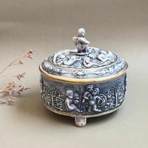 Joyero redondo vintage de Capodimonte con escena de putti azul y blanco, de porcelana italiana, con querubines, estilo rococó, decoración coleccionable.