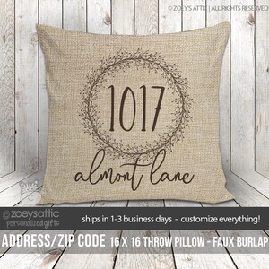 May include: A 16x16 inch throw pillow with a burlap texture. The pillow features a brown wreath with the address "1017 almont lane" printed on it.