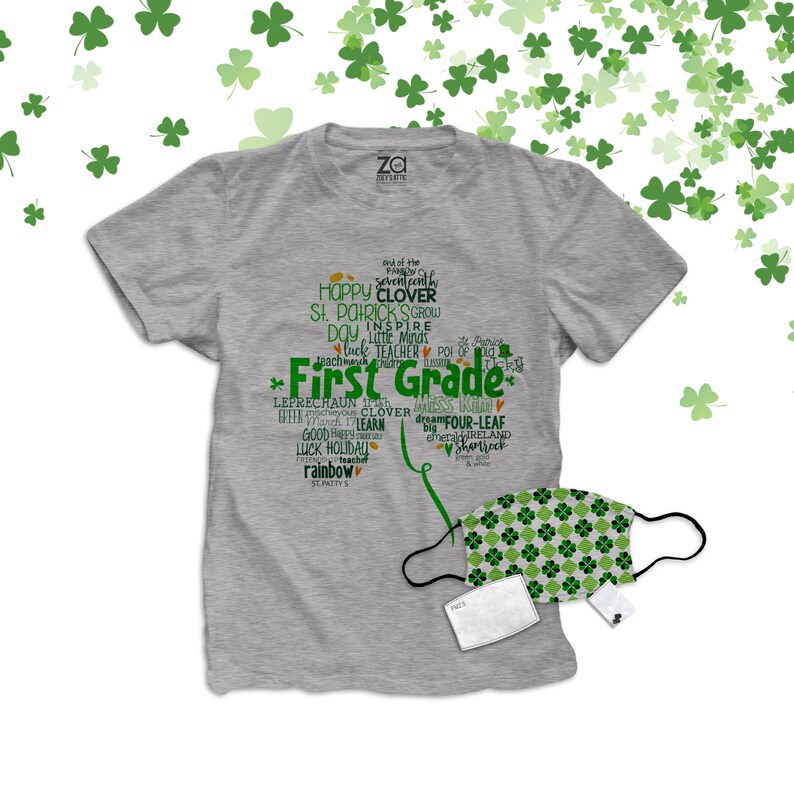 以下が含まれることがあります： 緑と白の模様で「First Grade」と書かれた灰色のTシャツ。クローバーと聖パトリックの日に関連する他の言葉も書かれています。緑と白の模様のフェイスマスクと白いフィルターが付属しています。