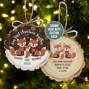 May include: Our First Christmas Together wood slice ornament with two foxes and a baby fox. The ornament is personalized with the names "Daddy", "Lily", and "Mommy" and the year "2022". The back of the ornament is personalized with the name "Lily Jane Largent", the date "March 17, 2022", the weight "9 lbs, 13 oz", and the time "6:21 PM".