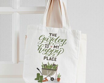 May include: White canvas tote bag with green text that reads "The Garden is my happy place". The bag features a green illustration of a wheelbarrow with plants, gardening tools, and boots.