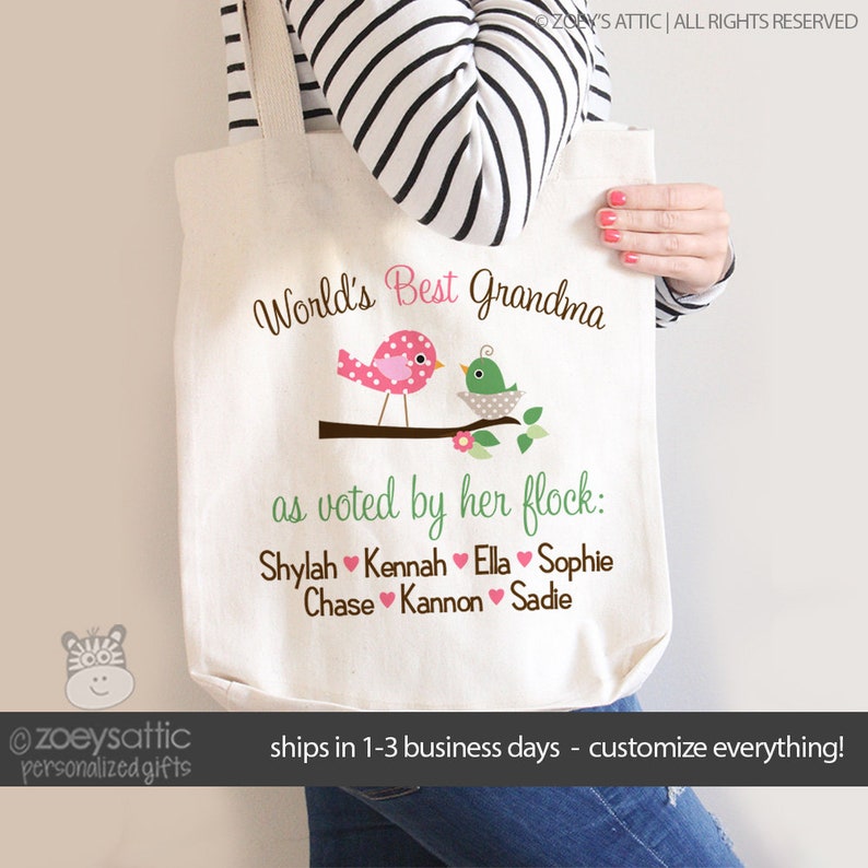 May include: A white canvas tote bag with the text "World's Best Grandma as voted by her flock: Shylah Kennah Ella Sophie Chase Kannon Sadie" and two cartoon birds on a branch.