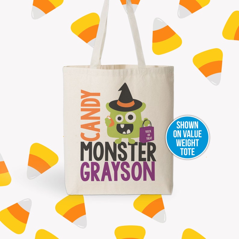 Puede incluir: Un monstruo verde con un sombrero de bruja morado sosteniendo un ma&iacute;z dulce. El texto en la bolsa de mano dice "Candy Monster Grayson" con una peque&ntilde;a bolsa morada que dice "Trick or Treat". La bolsa de mano es blanca con un fondo marr&oacute;n claro. La imagen est&aacute; rodeada de ma&iacute;z dulce amarillo y naranja.