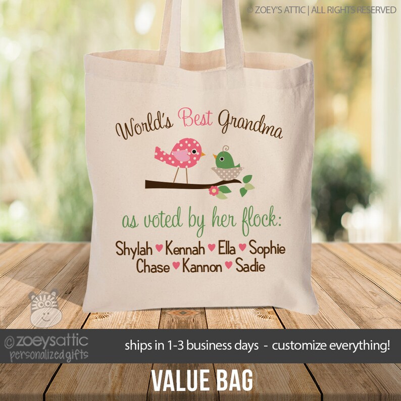 May include: A white canvas tote bag with the text "World's Best Grandma as voted by her flock: Shylah Kennah Ella Sophie Chase Kannon Sadie" and two cartoon birds on a branch.