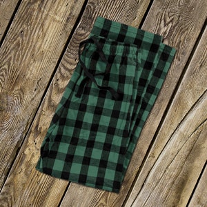 Op de afbeelding: Groene en zwarte geruite pyjamabroek met een zwart trekkoord.