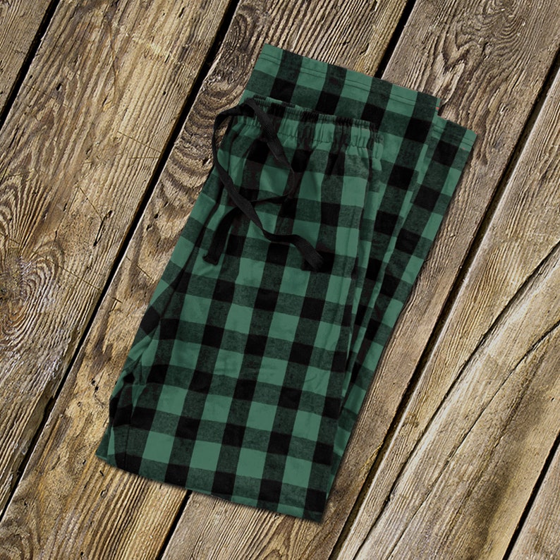 Op de afbeelding: Groene en zwarte geruite pyjamabroek met een zwart trekkoord.