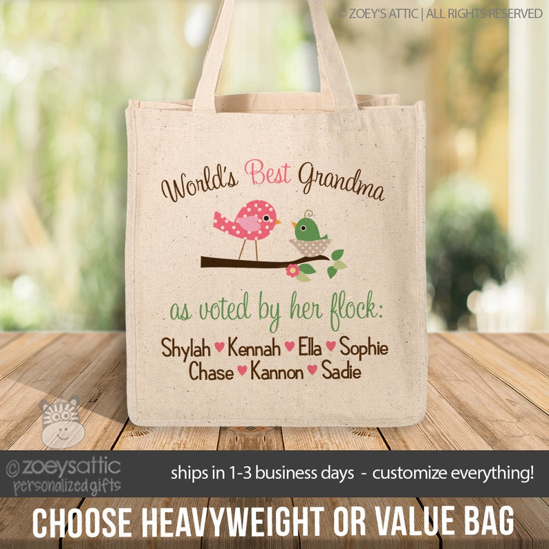 May include: A white tote bag with a pink and green bird design. The text "World's Best Grandma" is printed on the bag, along with the phrase "as voted by her flock:" and a list of names: Shylah, Kennah, Ella, Sophie, Chase, Kannon, Sadie.