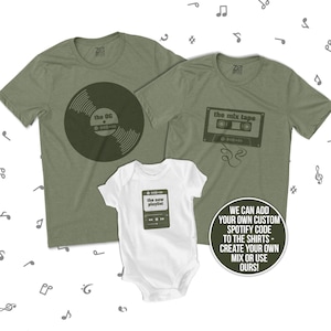 May include: Three green t-shirts with music-themed designs. The largest shirt has a vinyl record with the text "the OG". The medium shirt has a cassette tape with the text "the mix tape". The smallest shirt has a music player with the text "the new playlist".