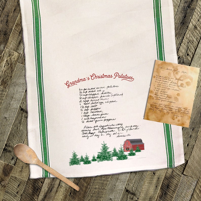May include: A white kitchen towel with green stripes and a red barn illustration. The towel features a handwritten recipe for "Grandma's Christmas Potatoes" with ingredients including potatoes, cheddar cheese, sour cream, and green peppers.