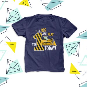 May include: Navy blue t-shirt with a construction theme. The shirt displays the text "Let's Dig and Play, I'm 1 Today!" alongside a yellow and black striped number 1 and a yellow bulldozer graphic. The name "William" is on the bulldozer.