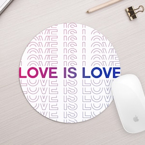 May include: A round white mousepad with a repeating pattern of the phrase "LOVE IS LOVE" in a gradient of pink and blue.