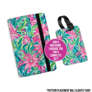 May include: A passport holder and matching luggage tag featuring a floral design in shades of pink, green and blue. The text "ADD A MATCHING LUGGAGE TAG FOR A COMPLETE SET!" is printed on the passport holder. The text "*PATTERN PLACEMENT WILL SLIGHTLY VARY" is printed below the image.